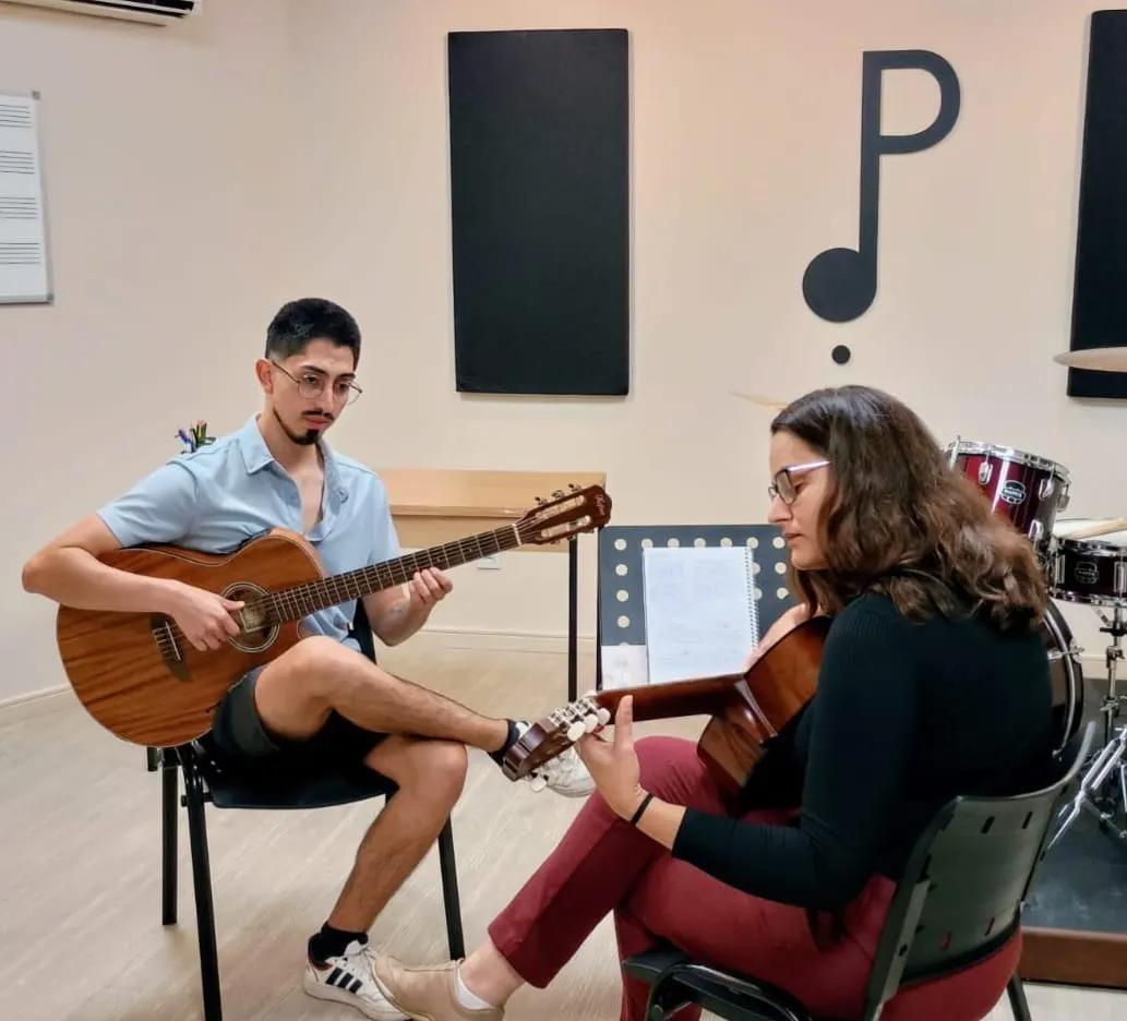 Professor e aluna em aula de violão